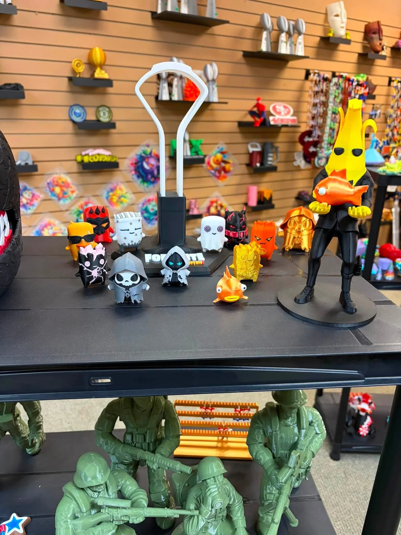 3D-printed character figures and small trophies displayed on shop shelving.