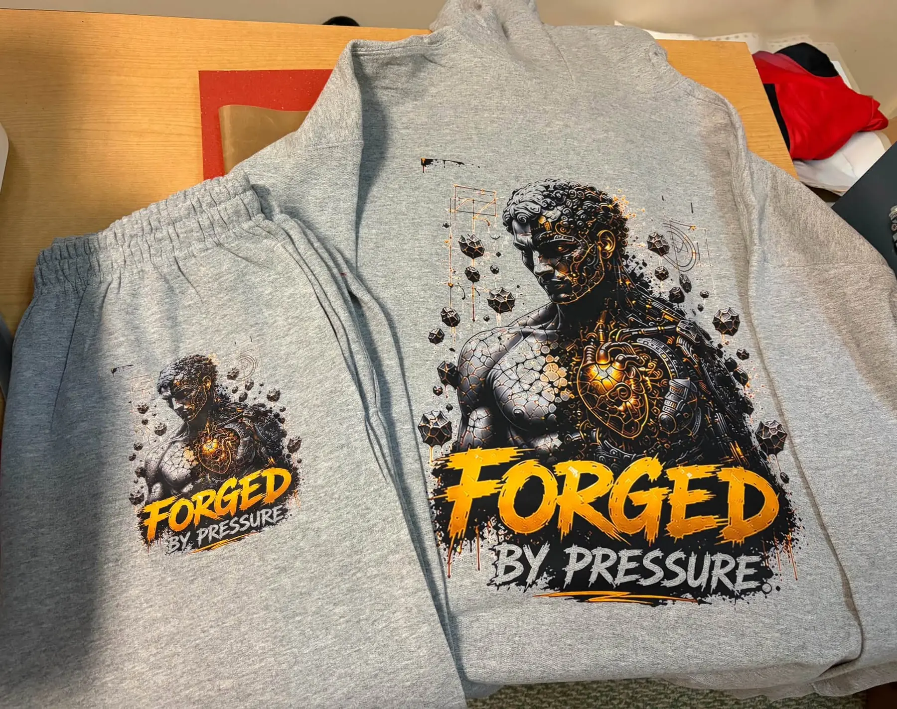 Custom-printed graphic design on a grey hoodie and matching sweatpants, folded and ready for pickup.