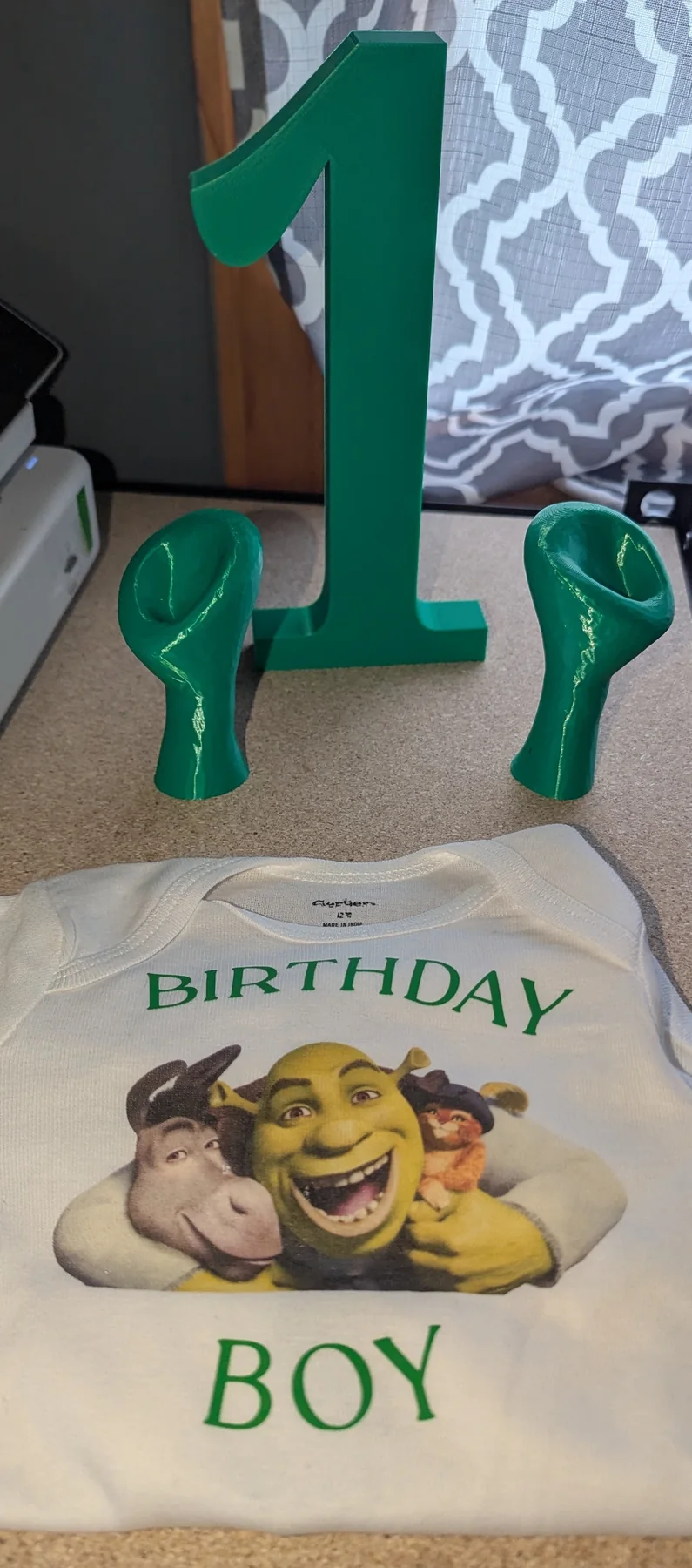 Personalized birthday onesie with a custom character graphic, shown with a 3D-printed number one.