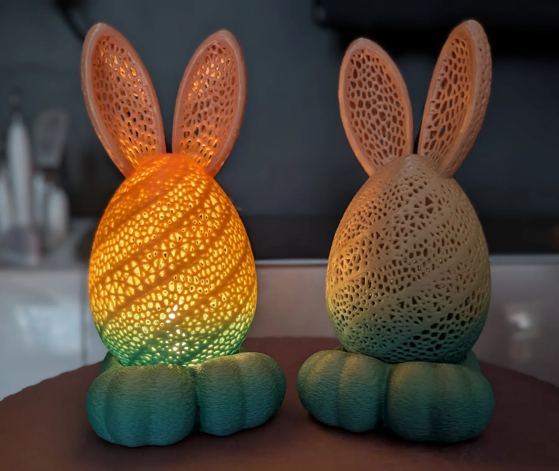 Two 3D-printed light-up rabbit figures with lattice-textured ears and bodies, one lit from within.